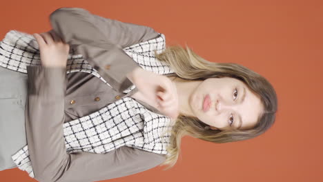 Vertical-video-of-Young-woman-looking-at-camera-with-a-negative-expression.